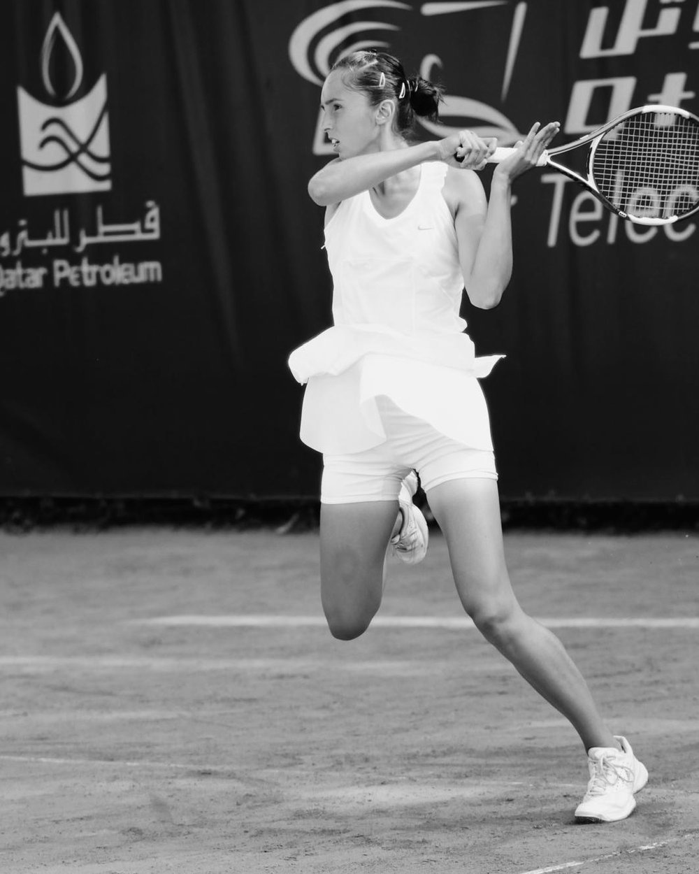 A Dedans member mid-rally on a clay court